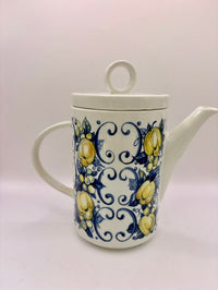Ceramic teapot with lemon and swirl design on a white background