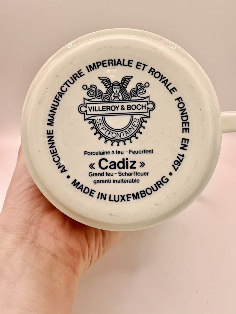 Villeroy & Boch mug handle with branding and text on a beige background
