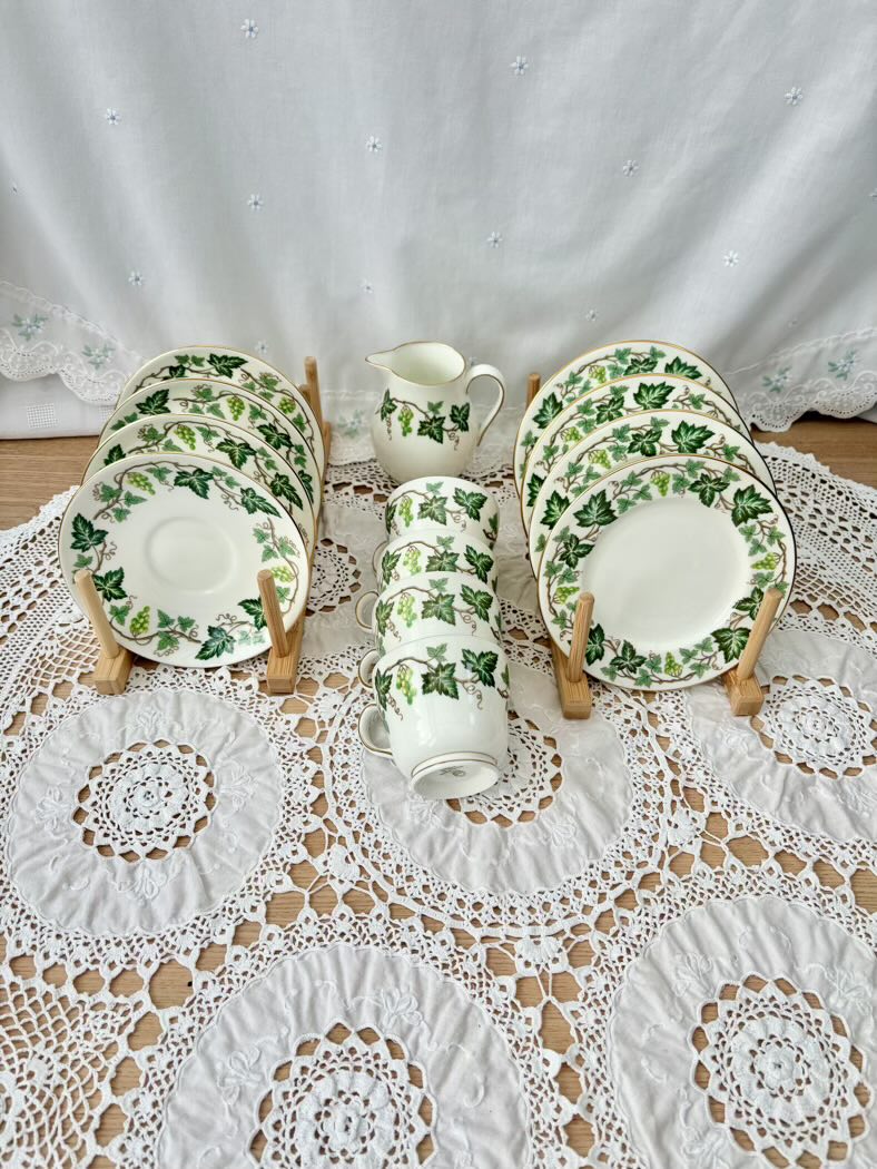 Set of ceramic plates with green leaf pattern on a lace tablecloth