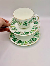 Teacup and saucers with green leaf pattern on a white background