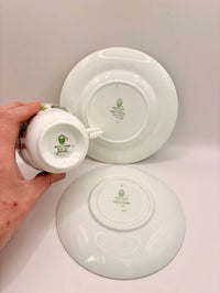 White ceramic plates with green logos on a gray background
