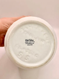 Close-up of a ceramic product with 'Old Foley' branding on a plain background