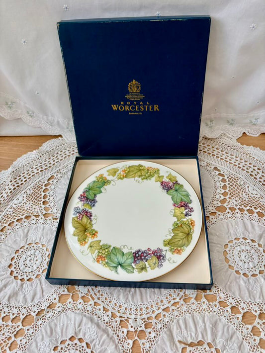 Royal Worcester plate with decorative border in a box on a lace tablecloth