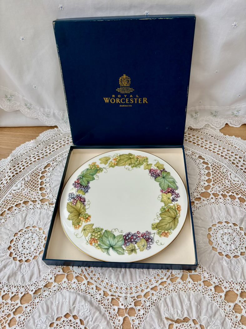 Royal Worcester plate with decorative border in a box on a lace tablecloth