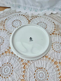 White ceramic plate with a logo on a lace tablecloth