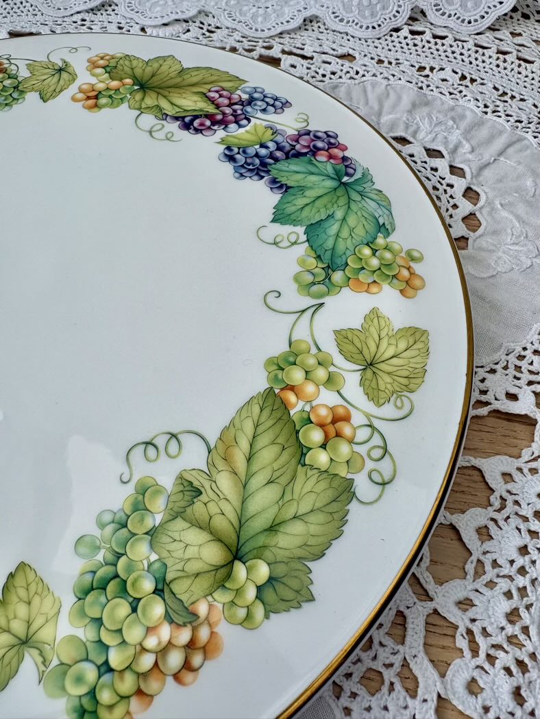 Decorative plate with grapevine design on a lace tablecloth