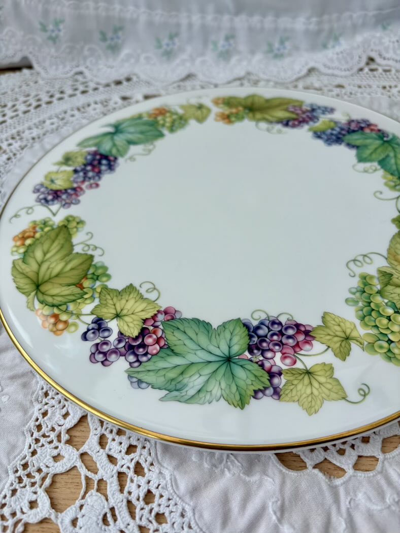 Decorative plate with grapevine design on a lace tablecloth