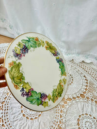 Decorative plate with leaf and berry design on a lace tablecloth
