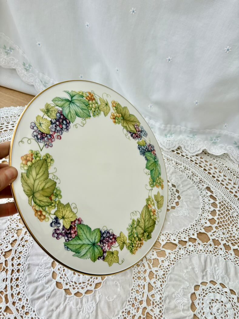 Decorative plate with leaf and berry design on a lace tablecloth