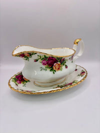 Decorative gravy boat with floral design on a white background