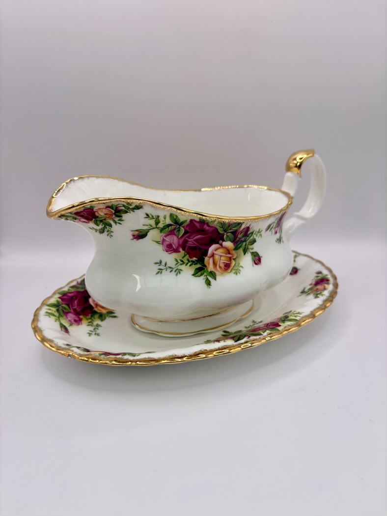 Decorative gravy boat with floral design on a white background