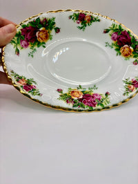 Decorative plate with floral patterns held by a hand on a plain background