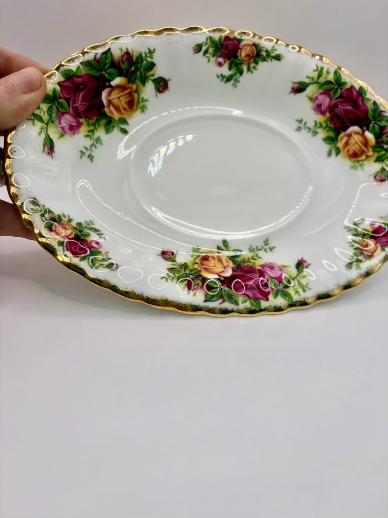 Decorative plate with floral patterns held by a hand on a plain background