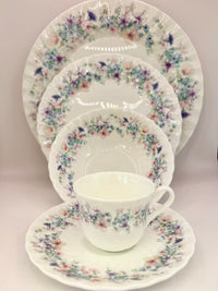 Floral patterned ceramic dinnerware set on a light background