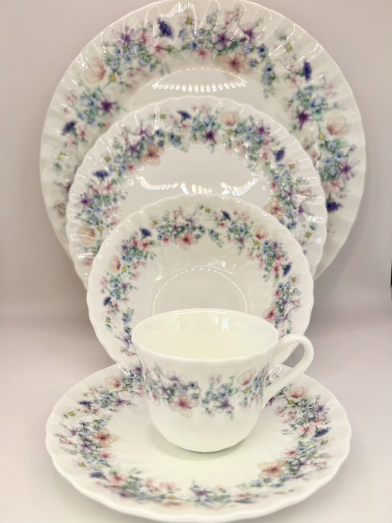 Floral patterned ceramic dinnerware set on a light background
