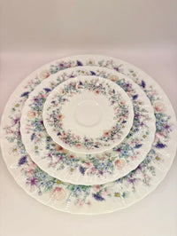 Set of floral-patterned ceramic plates stacked on a white background