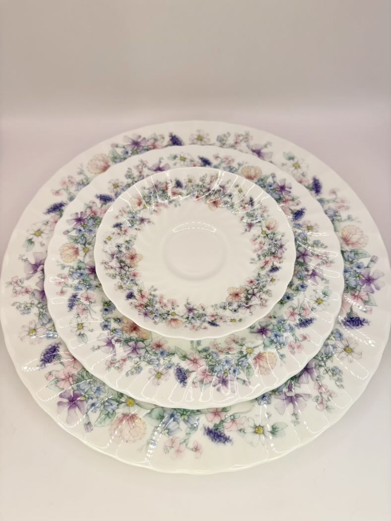 Set of floral-patterned ceramic plates stacked on a white background