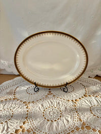 White oval plate with gold rim on a lace tablecloth