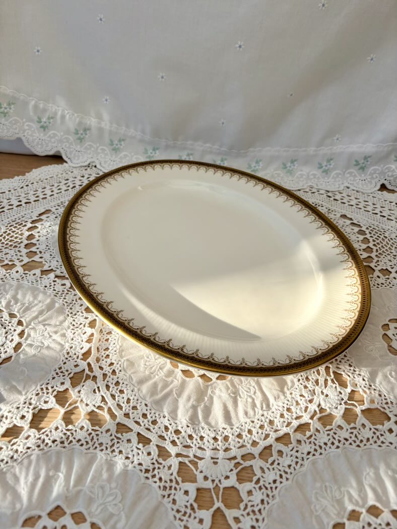 White plate with gold rim on a lace tablecloth
