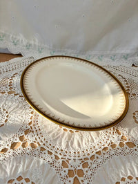 White plate with gold rim on a lace tablecloth