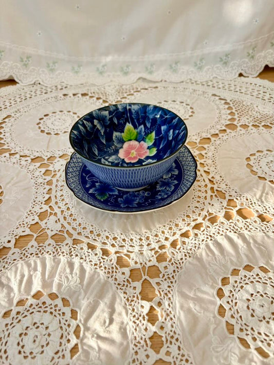 Blue ceramic bowl with floral design on a lace tablecloth
