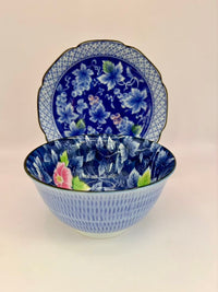 Blue floral ceramic bowl and plate set on a beige background