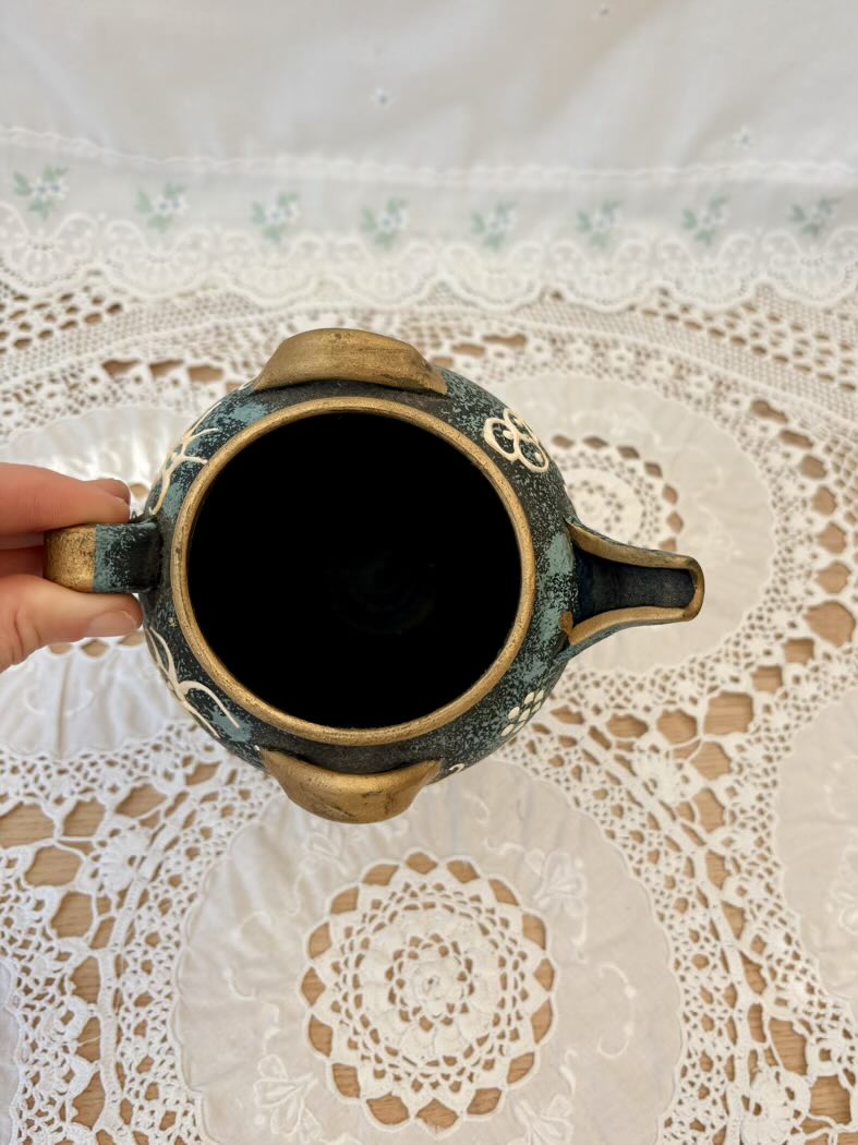 Ceramic vase filled with dark liquid on a lace tablecloth