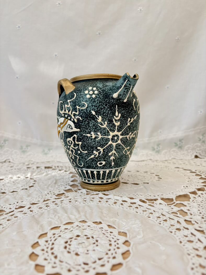 Decorative ceramic vase with floral patterns on a lace tablecloth