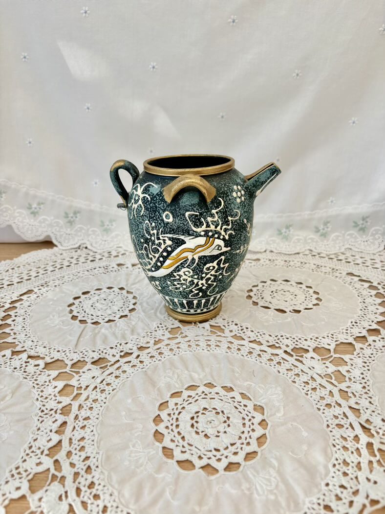 Ceramic vase with decorative patterns on a lace tablecloth