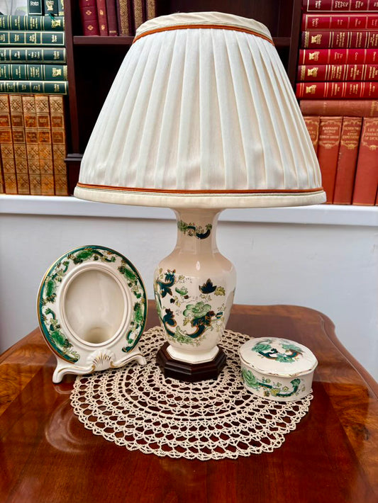 Decorative lamp with a pleated shade on a wooden table with books in the background
