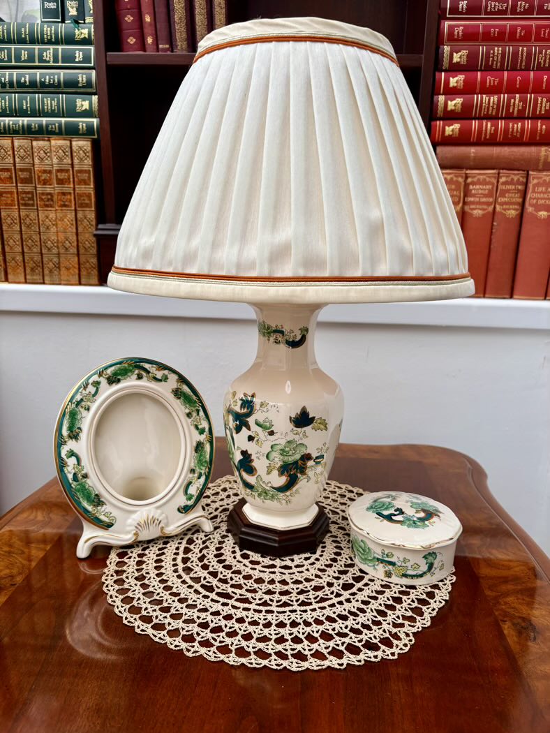 Decorative lamp with a pleated shade on a wooden table with books in the background
