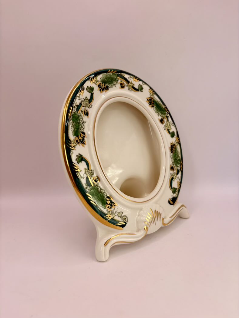 Decorative ceramic toilet seat with green and gold patterns on a pink background