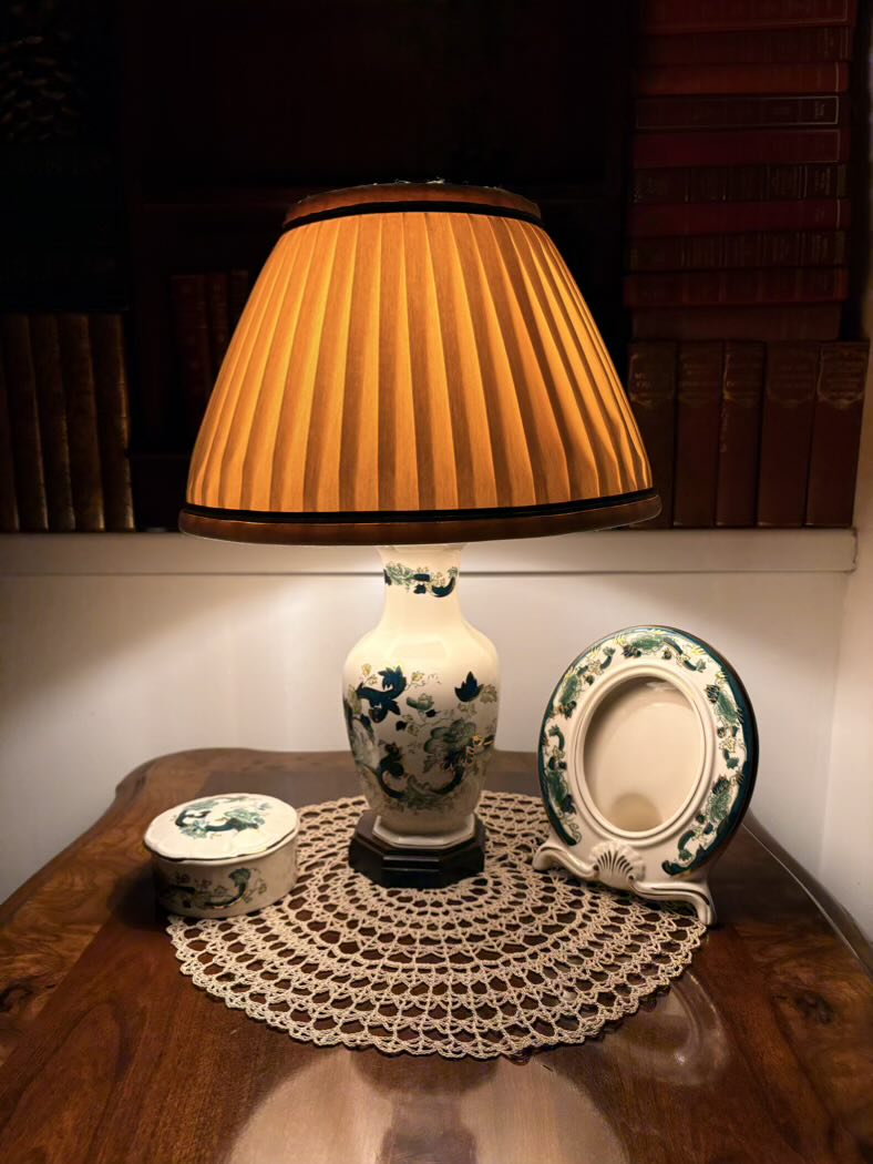 Lamp with pleated shade on a wooden surface with decorative items