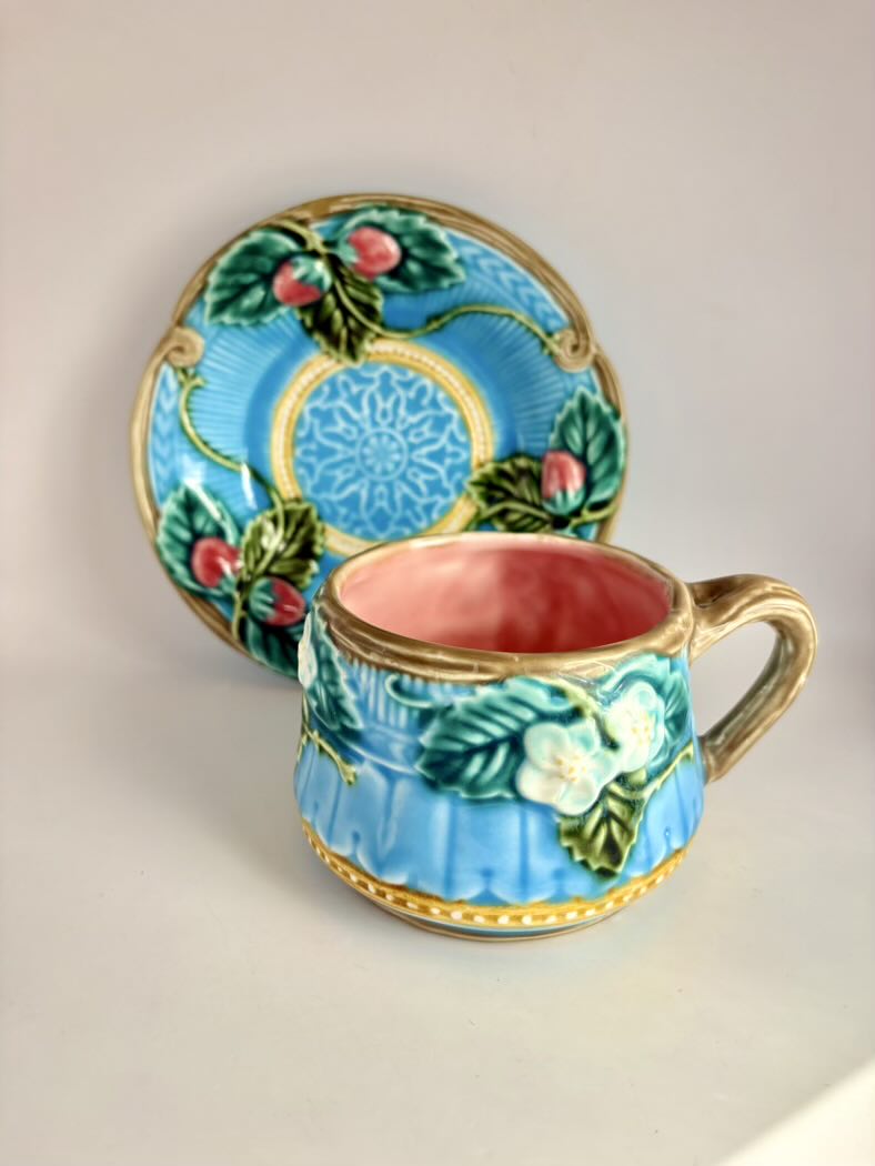 Decorative ceramic cup and saucer with floral patterns on a beige background
