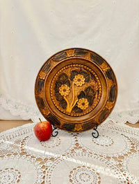 Decorative wooden plate with floral patterns on a lace tablecloth