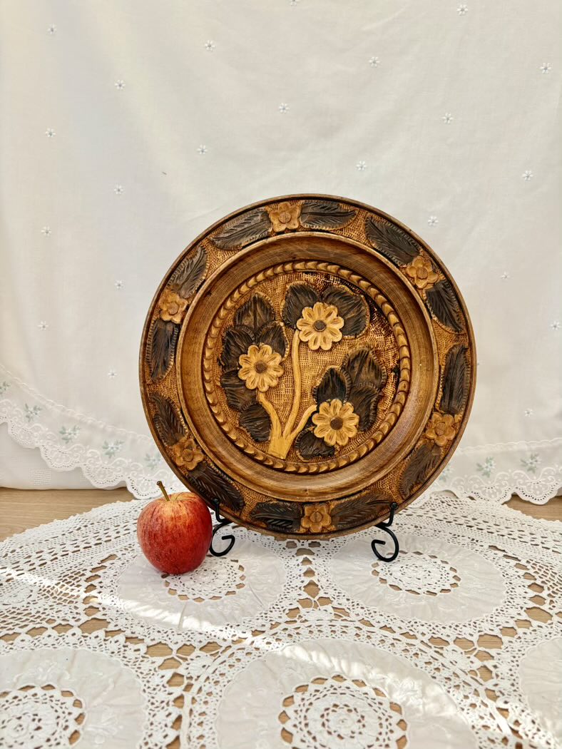 Decorative wooden plate with floral patterns on a lace tablecloth