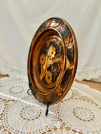 Decorative wooden plate with floral carvings on a lace tablecloth