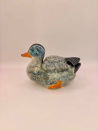Decorative stone duck figurine on a light background