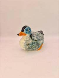Decorative duck figurine on a light beige background