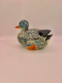 Ceramic duck figurine on a beige background