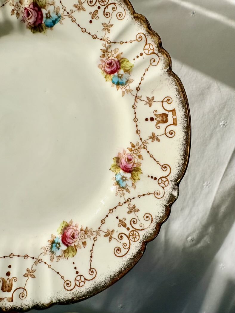 Decorative plate with floral and scroll designs on a white surface