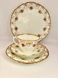 Tea set with cup, saucer, and plate featuring floral patterns on a white background