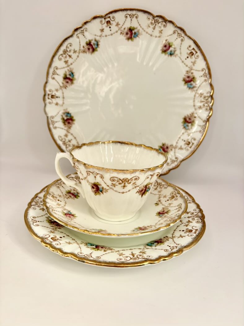 Tea set with cup, saucer, and plate featuring floral patterns on a white background
