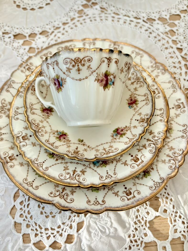 Vintage teacup and saucers with floral patterns on a lace tablecloth