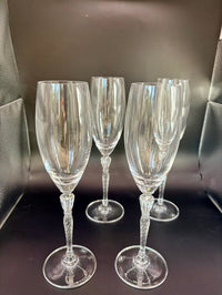 Four flutes arranged on a dark surface, two standing and two lying on their side