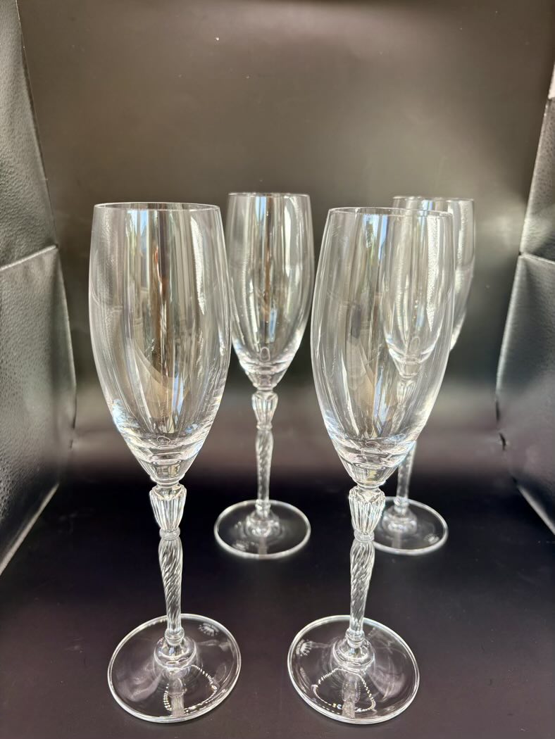 Four flutes arranged on a dark surface, two standing and two lying on their side