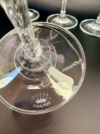 The base of one flute turned upside down, clearly showing the Royal Doulton logo etched into the glass