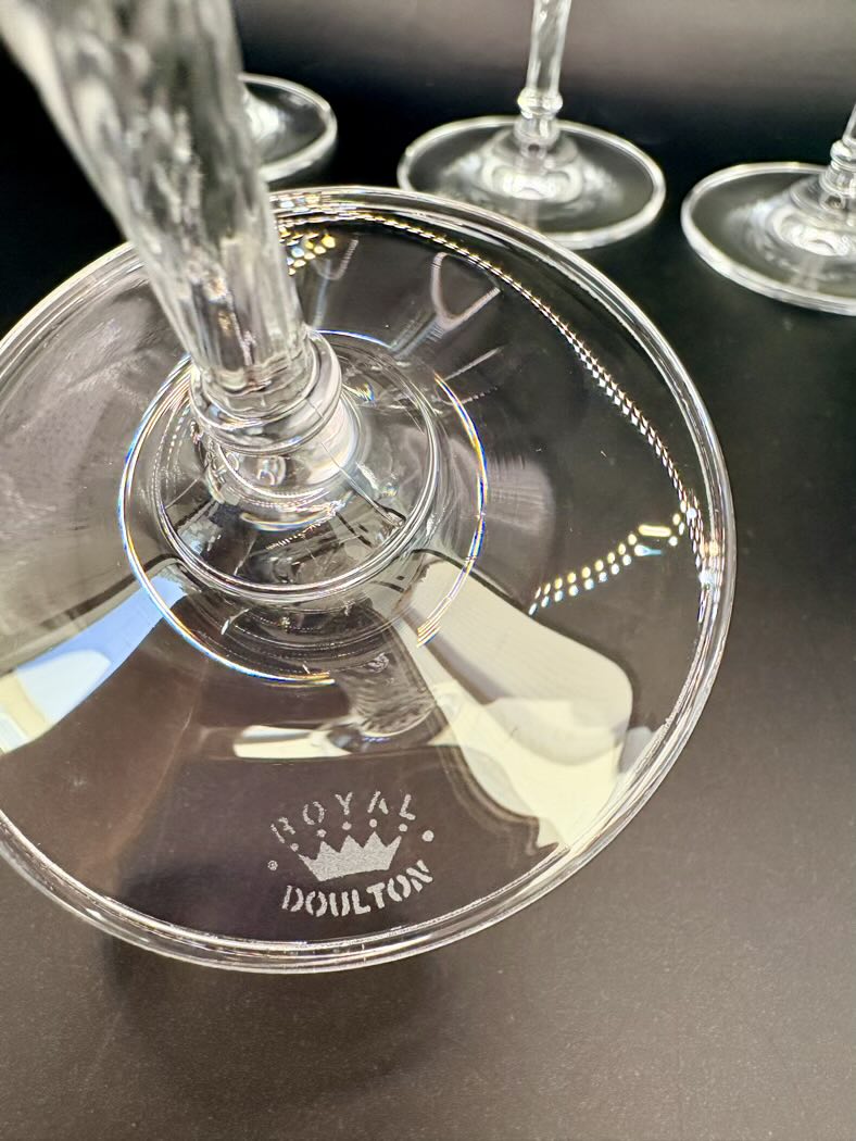 The base of one flute turned upside down, clearly showing the Royal Doulton logo etched into the glass