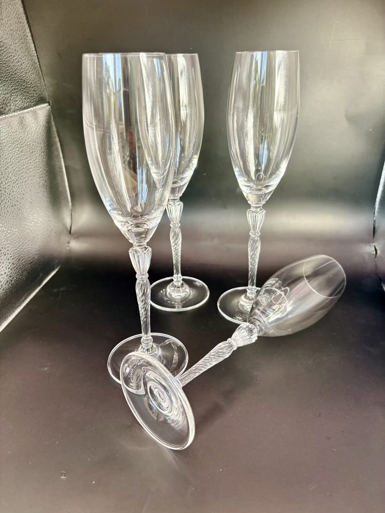 Four flutes arranged on a dark surface, two standing and two lying on their side