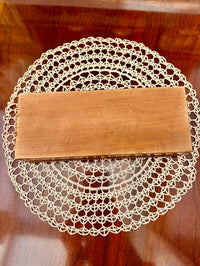 Wooden book on a lace doily on a wooden surface